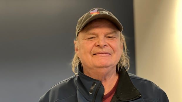 A portrait photo of a man in a baseball cap. 