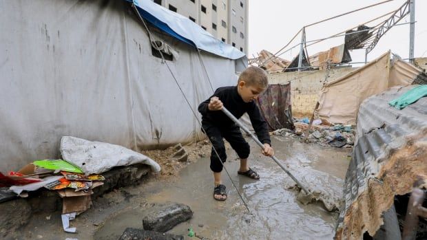 A child clears water from the ground.