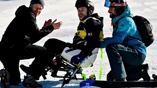 Prince Harry reacts next to sit ski athlete Neil Fellingham at the finals of the alpine skiing novice competition, on the ski slopes of Whistler Blackcomb.