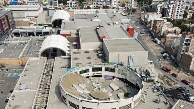 An aerial view shows a mall with a collapsed roof.