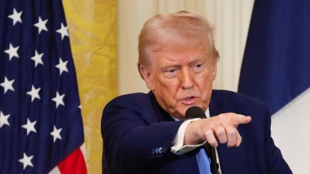 U.S. President Donald Trump standing behind a microphone at the White House.