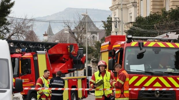 Emergency workers with vehicles with historical buildings in background.