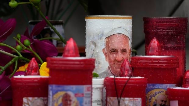 Rain drops are pictured on a candle with a senior mans face on it.