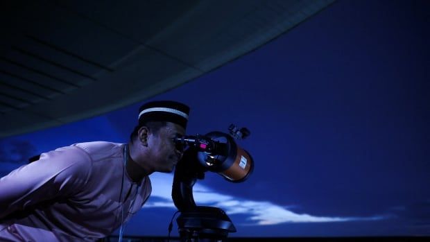 A Muslim looks through a theodolite to perform 'rukyah,' the sighting of the new moon which signals the start of the holy month of Ramadan