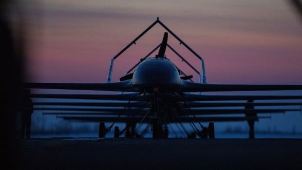 A plane is shown on a landing trip in a semi-darkened sky, either during sunrise or sunset