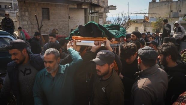 Men carry a body prepared for burial.