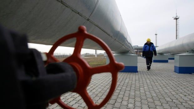 A workers walks next to gas pipelines.