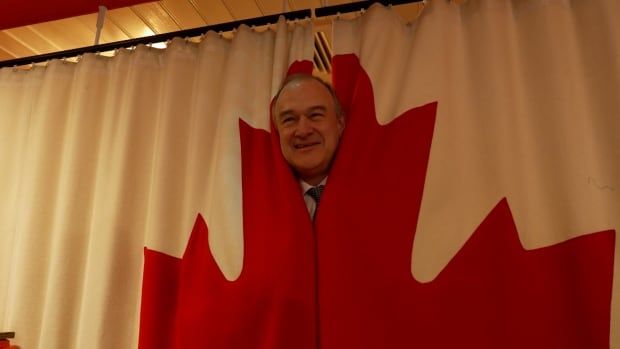 Ed Davey,  leader of the British Liberal Democrats,  poses with a Canadian flag in London Wednesday.