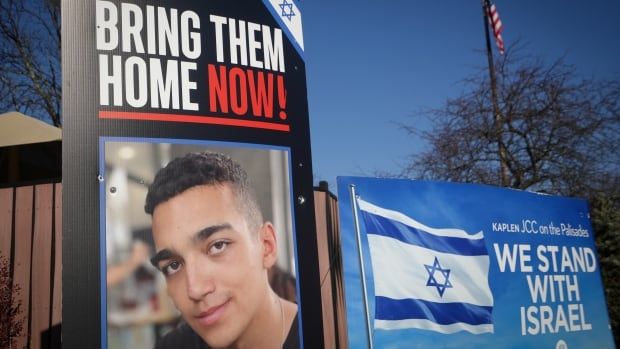 Signs and a photograph of Edan Alexander.