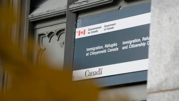 An Immigration, Refugees and Citizenship Canada sign is seen on the side of an old building in Montreal.