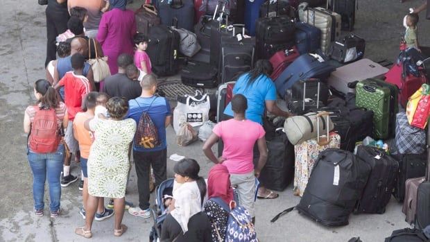 Asylum seekers line up to enter Olympic Stadium near Montreal.