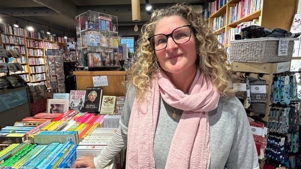 A woman poses in a book store.