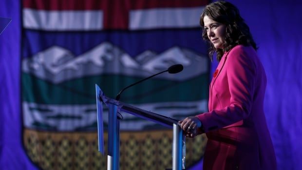 A woman stands behind a podium.