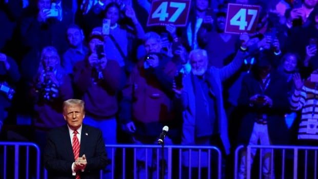 Trump in front of crowd in blue light