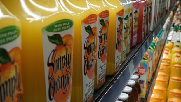 A grocery store shelf displays a row of orange juice.