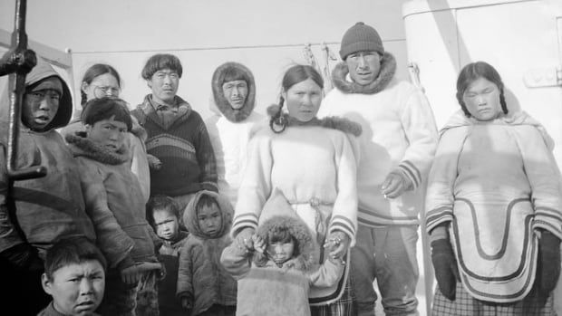 A black and white photo of a group of Inuit on a ship.