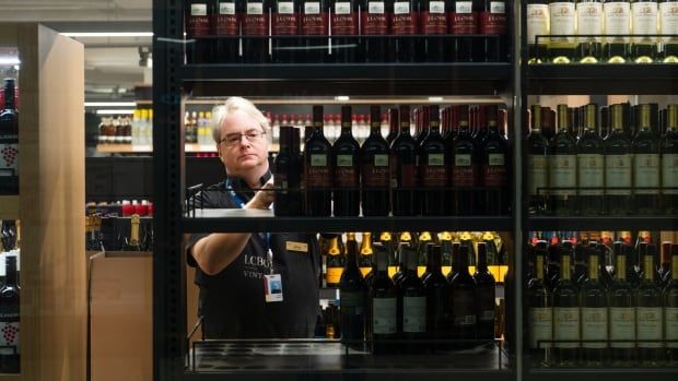 An LCBO employee moves products in an LCBO store at Union Station in Toronto on Tuesday, March 4, 2025.