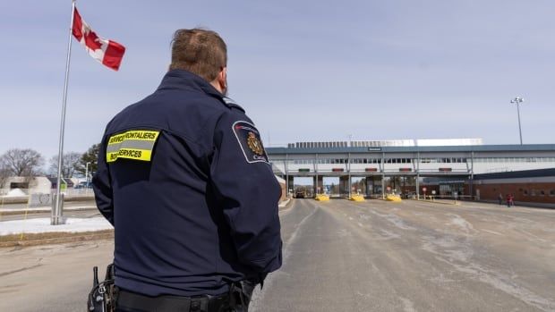 A Canada Border Services officer watches as vehicles enter Canada from Vermont at the Highway 55 Port of Entry in Stanstead, Que., Thursday, March 13, 2025.