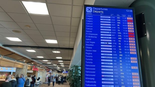 An arrivals /departures board at Edmonton International Airport on Friday 12 Jan 2024 shows many late flights listed.