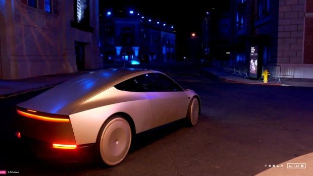 A bronze coloured electric vehicle is shown at an event.