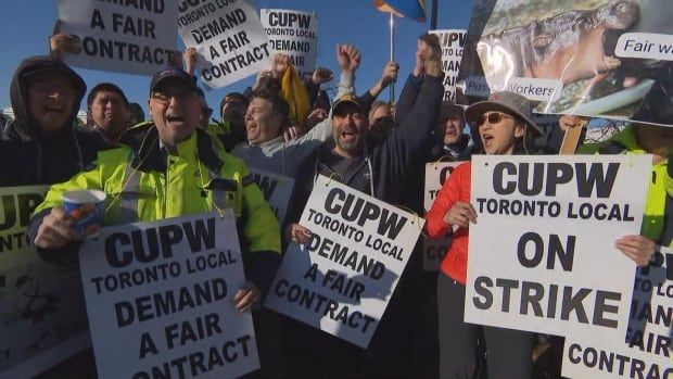 Canada Post employees cheering and holding signs 