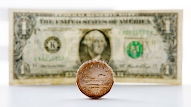 A Canadian dollar coin, commonly called a "Loonie" and an American dollar bill are seen in this staged photo in Toronto, March 17, 2010