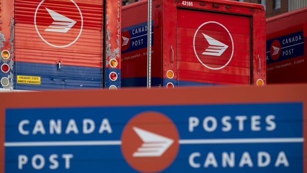 Canada Post signage and parked red vehicles at a Canada Post mail sorting facility 