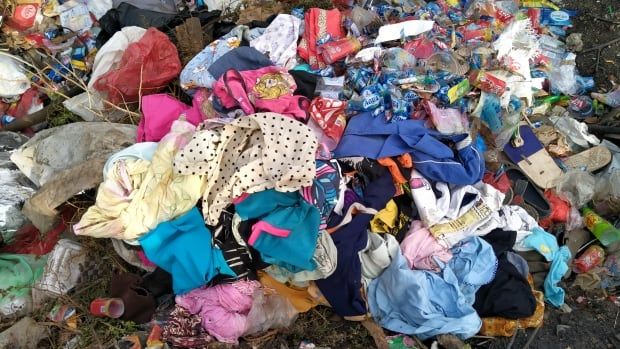 Clothing waste is pictured in a landfill.