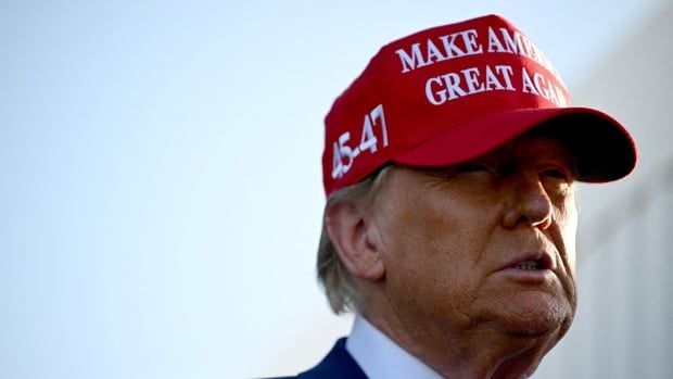 A man in a suit and bright red hat is pictured. The ballcap says "Make American Great Again".