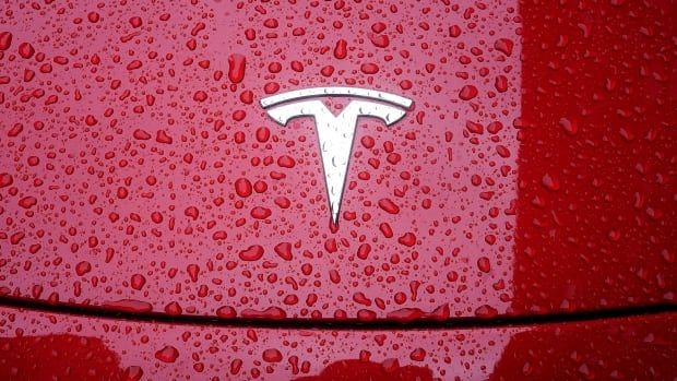 A logo of Tesla is seen on a car. 