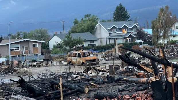 Part of a town lies in charred ruins.