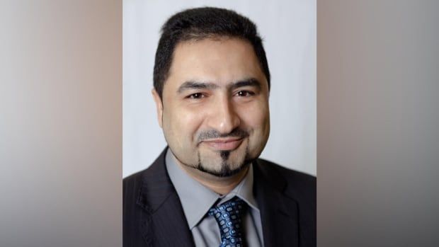 A portrait of a middle-aged man with dark hair and a goatee, wearing a suit.