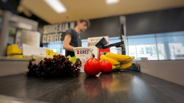 Groceries are shown on a checkout counter conveyor belt. 