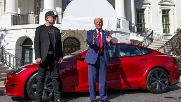 U.S. President Donald Trump talks to the media next to Tesla CEO Elon Musk, with a Tesla car in the background, at the White House in Washington, D.C., U.S., March 11, 2025.