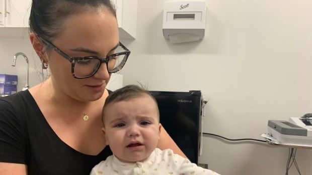 A mother and baby in a doctor's examining room.