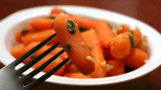 Coconut-ginger baby carrots on a fork.