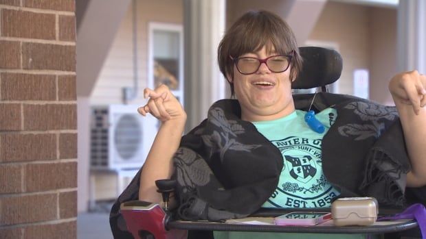 A woman in a wheel chair with short hair and glasses