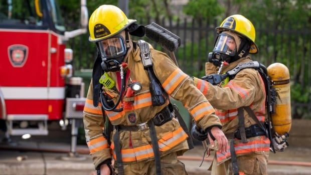 Two firefighters at the scene of a fire.