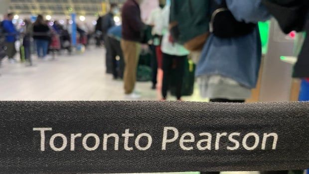 Travellers stand in line at Pearson International Airport in Toronto. 