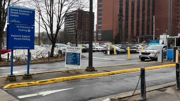 A parking lot with a hospital in the background.