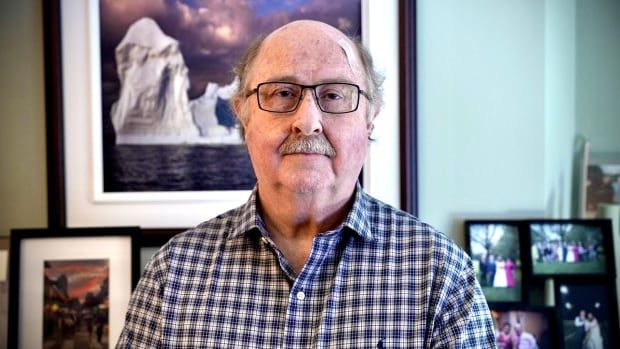 A white man in a plaid shirt and glasses.