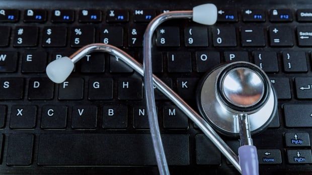 A stethoscope on the keyboard of a laptop.