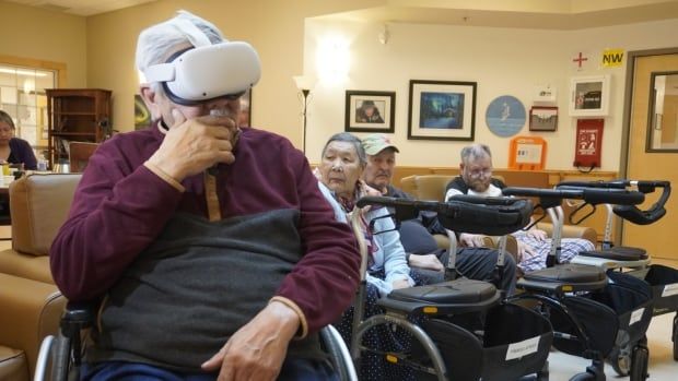 Man sits in wheelchair wearing white googles.