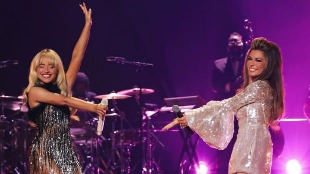 Sabrina wears a sparkly fringe dress while Shania wears a sequined white dress.