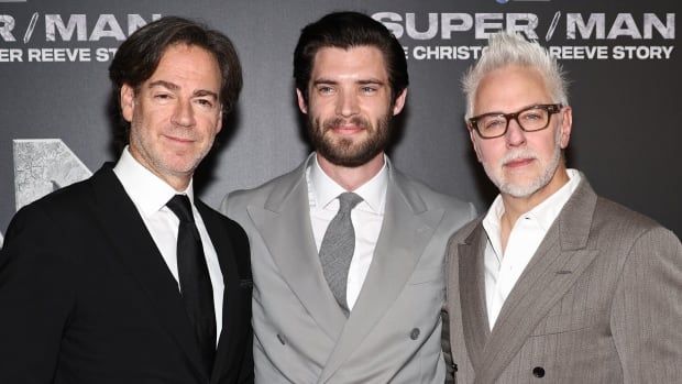 Three men pose for a photo. 