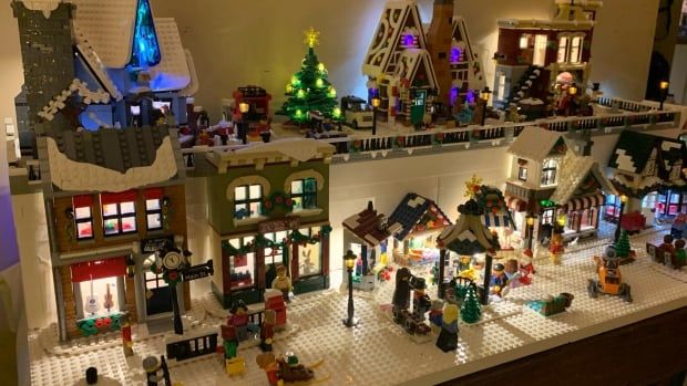 Winter-themed Lego sets forming a small village scene sit on a shelf.