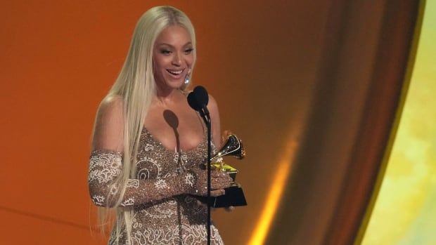 Beyonce smiles as she accepts an award. 