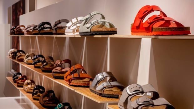 Sandals are displayed on shelves at a store.