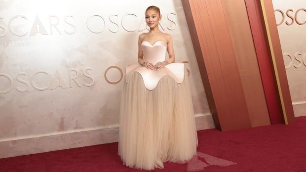 Ariana Grande on the red carpet wearing sculptural pale pink and beige gown.