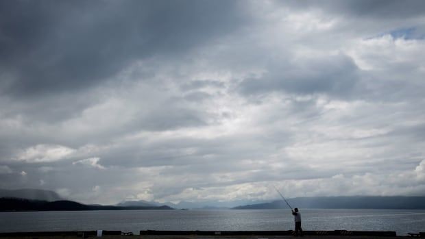 A person fishes on the end of a wharf 